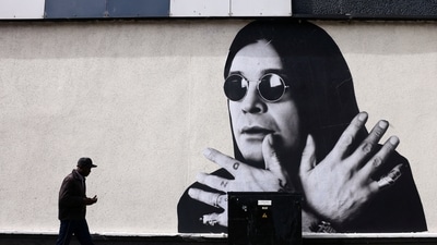 A man passes by a mural of Ozzy Osbourne ahead of his funeral cortege. (Jack Taylor/REUTERS)