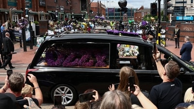 A close up of one of the black cars in the funeral procession carrying a floral arrangement that reads 'OZZY', made of dark purple flowers honouring the late rocker. (Jack Taylor/REUTERS)