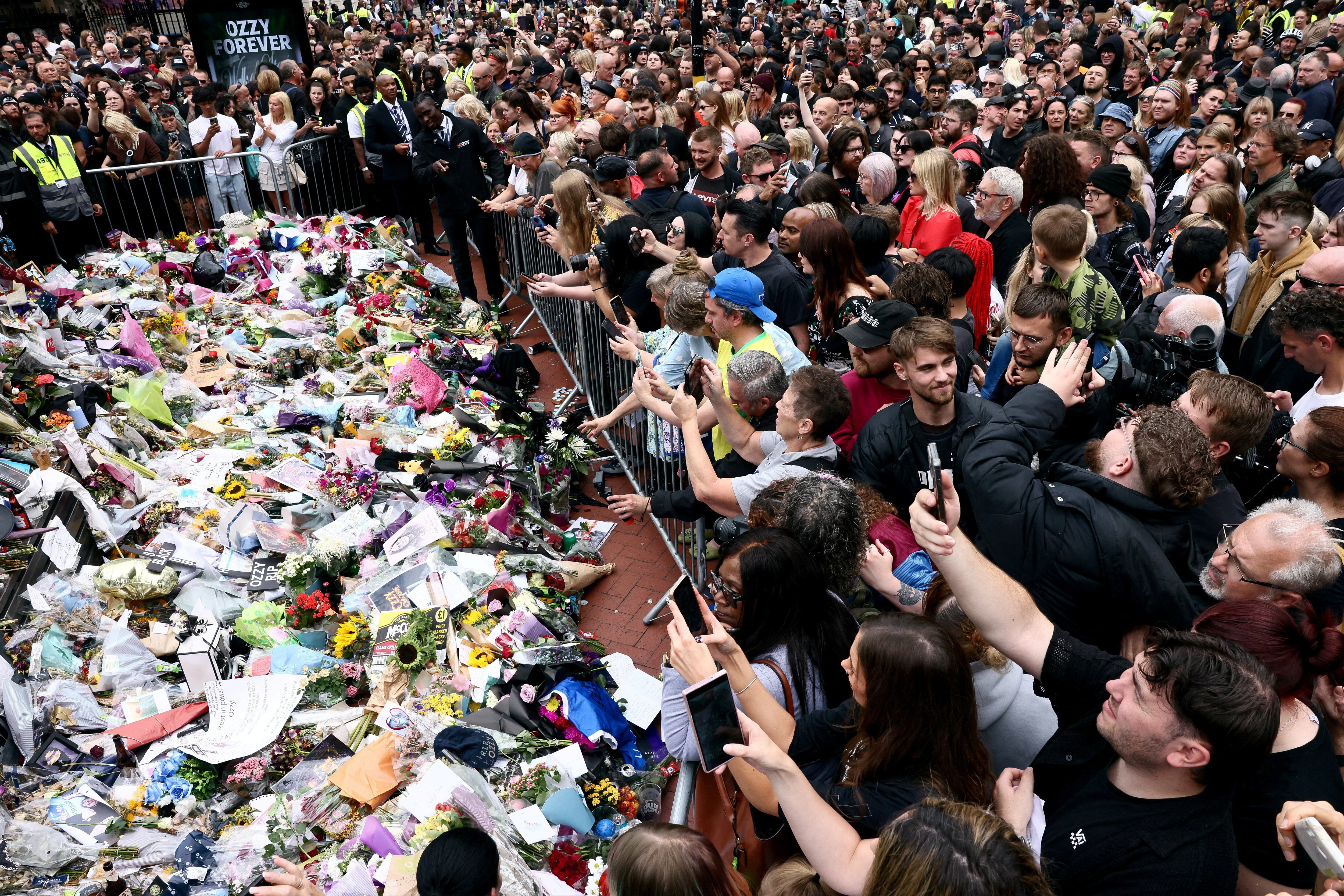 People gather around tributes placed at the Black Sabbath Bridge, named in honour of the heavy metal band, on the day of the funeral cortege of Ozzy Osbourne, its former frontman, in Birmingham, Britain, July 30, 2025. REUTERS/Jack Taylor     TPX IMAGES OF THE DAY (REUTERS)