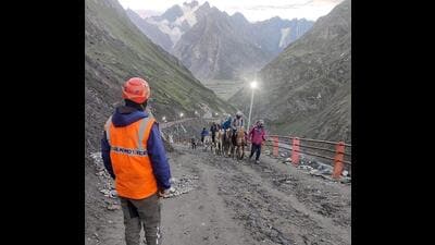 A member of the Jammu and Kashmir Police’s Mountain Rescue Team (MRT) stands guard as pilgrims move towards the holy cave shrine during the annual Amarnath Yatra in Anantnag district on Thursday. (PTI Photo)