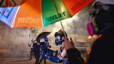 Pro-democracy protesters react from tear gas fired by the police outside Tsim Sha Tsui Police station during a demonstration against the controversial extradition bill in Hong Kong on August 11, 2019 (AFP FILE)