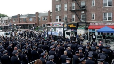 Police officers gather in front of an LED screen lit up in honor of the NYPD officer Didarul Islam during his funeral. REUTERS/Jeenah Moon (REUTERS)