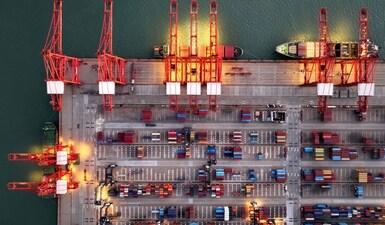 Container ships are seen at the container terminal at Lianyungang port, in China’s eastern Jiangsu province in the early morning on July 24,