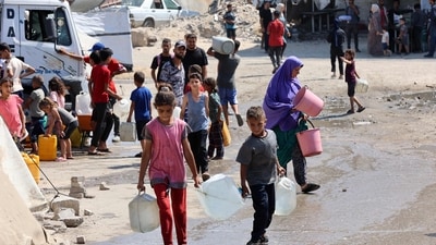 Small children in war-ravaged Gaza haul heavy gallons of clean water, each step a struggle for survival. (Omar Al-Qattaa/AFP)