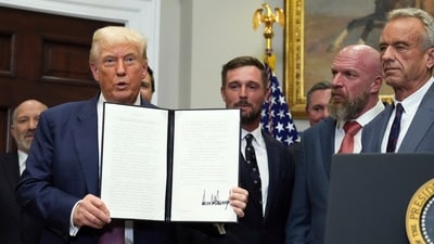 President Donald Trump holds up a signed executive order restarting the Presidential Fitness Test in public schools as Commerce Secretary Howard Lutnick, from left, professional golfer Bryson DeChambeau, WWE CCO Triple H and Health and Human Services Secretary Robert F. Kennedy Jr. watch. (AP) President Donald Trump holds up a signed executive order restarting the Presidential Fitness Test in public schools as Commerce Secretary Howard Lutnick, from left, professional golfer Bryson DeChambeau, WWE CCO Triple H and Health and Human Services Secretary Robert F. Kennedy Jr. watch. (AP)