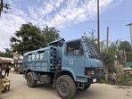 A CRPF vehicle moving past people standing on a roadside during an encounter between terrorists and security forces in the Akhal area of Kulgam district on Saturday. (PTI Photo) A CRPF vehicle moving past people standing on a roadside during an encounter between terrorists and security forces in the Akhal area of Kulgam district on Saturday. (PTI Photo)