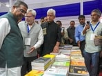 Union education minister Dharmendra Pradhan with Jammu and Kashmir Lt governor Manoj Sinha at a stall during inaugural ceremony of the 'Chinar Book Festival', at SKICC in Srinagar, Saturday. (PTI)