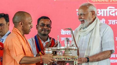 Chief minister Yogi Adityanath presents a handcrafted Shivling to Prime Minister Narendra Modi in Varanasi on Saturday. (ANI PHOTO)