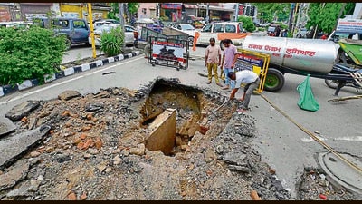 Civic body workers repairing the portion of the road that caved in near Mintgumri Chowk, Model Town, in Ludhiana on Saturday. (Gurpreet Singh/HT) Civic body workers repairing the portion of the road that caved in near Mintgumri Chowk, Model Town, in Ludhiana on Saturday. (Gurpreet Singh/HT)