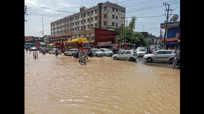 Commuters wade through a waterlogged road after heavy rainfall in Himachal's Una district on Saturday. (PTI) Commuters wade through a waterlogged road after heavy rainfall in Himachal's Una district on Saturday. (PTI)