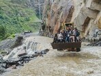 An excavator being used to assist people to cross a stream in Lahaul and Spiti district of Himachal Pradesh. An excavator being used to assist people to cross a stream in Lahaul and Spiti district of Himachal Pradesh.