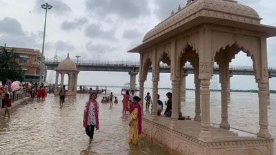 People stand on the banks of the swollen Ganga, as intense floods hit Varanasi. (Rajesh Kumar/HT)