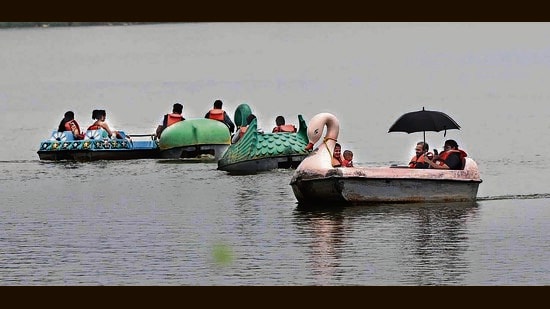 Visitors enjoying the rainy weather at Sukhna Lake in Chandigarh on Sunday. (Keshav Singh/HT)