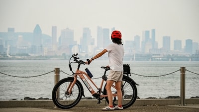 A person stands with a bicycle as smoky haze from wildfires, with a poor air quality rating, covers the skyline of Montreal, Quebec, Canada August 3 (REUTERS)