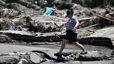 A woman walks past a flood damaged area from heavy rains over the last few days in Huairou district, on the outskirts of Beijing on July 30, 2025. (AFP) A woman walks past a flood damaged area from heavy rains over the last few days in Huairou district, on the outskirts of Beijing on July 30, 2025. (AFP)