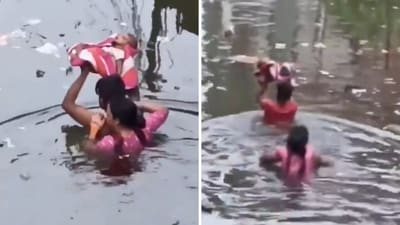 The family slowly made their way through the murky water, which had garbage flowing in it, as the infant was held above their heads. (X/WeatherMonitors) The family slowly made their way through the murky water, which had garbage flowing in it, as the infant was held above their heads. (X/WeatherMonitors)