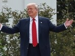 President Donald Trump gestures to reporters during his walk on the White House roof
