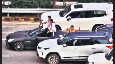 Two other men are seen recording videos, while other members of the group cheered from adjoining vehicles, some of them standing on footrests and others coming out of the sunroofs. The cars had illegally installed sirens, which were blared continuously, the residents alleged. (HT PHOTO) Two other men are seen recording videos, while other members of the group cheered from adjoining vehicles, some of them standing on footrests and others coming out of the sunroofs. The cars had illegally installed sirens, which were blared continuously, the residents alleged. (HT PHOTO)