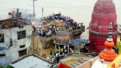 In Varanasi, family members were seen attending cremation ceremonies of their relatives from buildings while being surrounded by the flooded Manikarnika Ghat. (PTI)