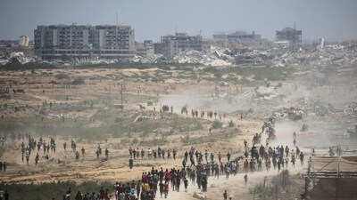 Palestinians rush to the scene as air pallets, carrying humanitarian aid, parachute down after being dropped from a military plane over Nuseirat in the central Gaza Strip during an airdrop mission above the Israel-besieged Palestinian territory on August 5, 2025. (AFP) Palestinians rush to the scene as air pallets, carrying humanitarian aid, parachute down after being dropped from a military plane over Nuseirat in the central Gaza Strip during an airdrop mission above the Israel-besieged Palestinian territory on August 5, 2025. (AFP)