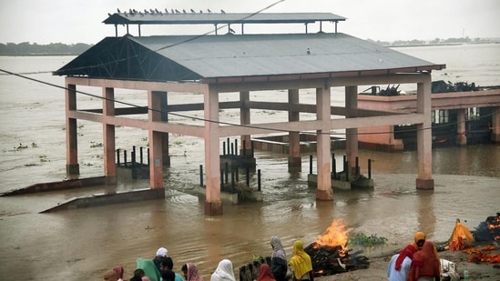 Amid the high water level of the Ganga River, family members are forced to cremate dead bodies outside at Digha Ghat.&nbsp;(Santosh Kumar/ Hindustan Times)