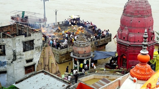 In Varanasi, family members were seen attending cremation ceremonies of their relatives from buildings while being surrounded by the flooded Manikarnika Ghat.(PTI)