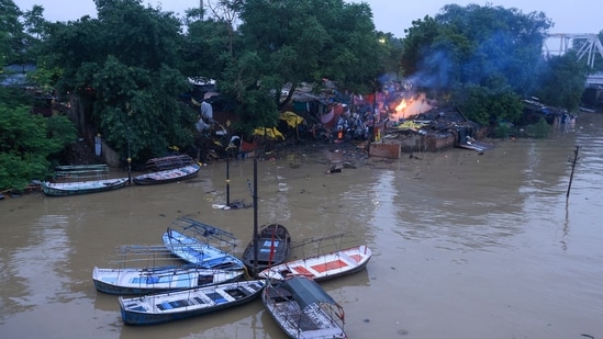 Visuals showed people attending the funeral ceremonies at the waterlogged bank of the swollen River Ganga in Prayagraj(PTI)