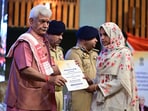 J&K LG Manoj Sinha hands over a job letter to family member of terror victim in Srinagar on Tuesday. (Waseem Andrabi /HT)