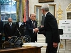 Apple CEO Tim Cook shakes hands with US President Donald Trump at the Oval Office