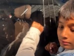 A kid knocks at the window of Mohammed Siraj's car