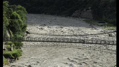 A man walks on a suspended bridge along the Bhagirathi river after heavy rainfall in Chinyalisour, Uttarakhand. (REUTERS)