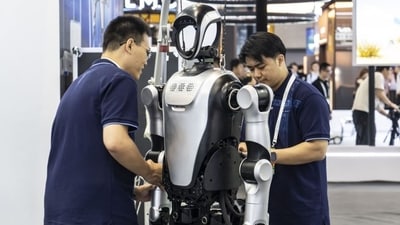 Employees service a Leju robot at the World Artificial Intelligence Conference (WAIC) 2025 in Shanghai, China, on Saturday, July 26 (Bloomberg)