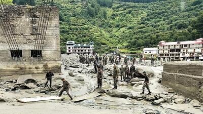 Security and relief personnel build a crossing across a stream of dense sludge during a search and rescue operation on Wednesday. (AFP) Security and relief personnel build a crossing across a stream of dense sludge during a search and rescue operation on Wednesday. (AFP)