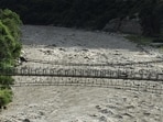 A man walks on a suspended bridge along the Bhagirathi river after heavy rainfall in Chinyalisour, Uttarakhand. (REUTERS)