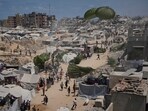 Palestinians rush to collect humanitarian aid airdropped by parachutes into Gaza City, northern Gaza Strip.