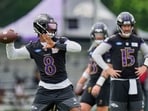 Baltimore Ravens quarterback Lamar Jackson (8) throws as quarterbacks Devin Leary (13) and Cooper Rush (15) watch