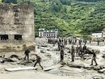 Security and relief personnel build a crossing across a stream of dense sludge during a search and rescue operation on Wednesday. (AFP)
