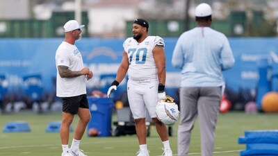 Los Angeles Chargers offensive tackle Rashawn Slater (70) talks to a coach on the field during an NFL training camp Monday (AP) Los Angeles Chargers offensive tackle Rashawn Slater (70) talks to a coach on the field during an NFL training camp Monday (AP)