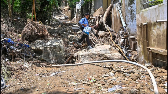 A girl makes way through the debris in flood-ravaged Mandi, in Himachal Pradesh, on Thursday. (PTI)