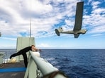 A crewmember aboard the Royal Canadian Navy coastal defense vessel HMCS Moncton launches an RQ-20 Puma drone