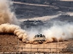An Israeli army infantry-fighting vehicle (IFV) leaves a cloud of dust as it moves at a position along Israel's southern border with the Gaza Strip.