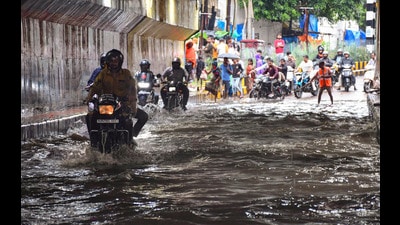 Commuters move through a waterlogged road at George Town area after heavy rainfall, in Prayagraj, on Friday. (PTI) Commuters move through a waterlogged road at George Town area after heavy rainfall, in Prayagraj, on Friday. (PTI)