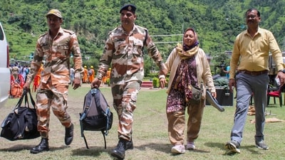 Indian Army personnel hold hands of stranded citizens on Thursday as they bring them to Matli helipad for safe evacuation after the deadly floods hit Uttarakhand. (PTI) Indian Army personnel hold hands of stranded citizens on Thursday as they bring them to Matli helipad for safe evacuation after the deadly floods hit Uttarakhand. (PTI)