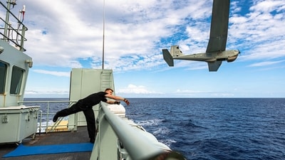 A crewmember aboard the Royal Canadian Navy coastal defense vessel HMCS Moncton launches an RQ-20 Puma drone (via REUTERS)