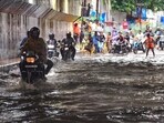 Commuters move through a waterlogged road at George Town area after heavy rainfall, in Prayagraj, on Friday. (PTI) Commuters move through a waterlogged road at George Town area after heavy rainfall, in Prayagraj, on Friday. (PTI)