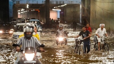 Commuters on Saturday waded through knee-high water from a waterlogged underpass in New Delhi (PTI) Commuters on Saturday waded through knee-high water from a waterlogged underpass in New Delhi (PTI)