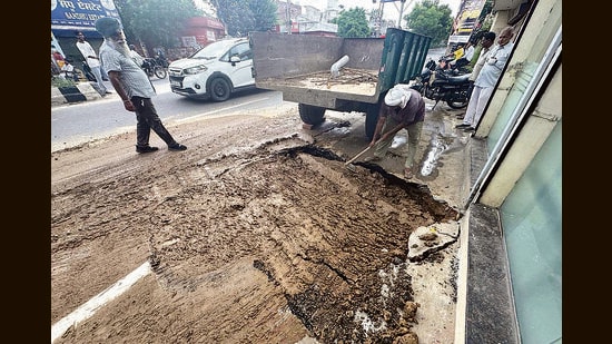 A civic body worker conducting repair work at the cave-in site on Pakhowal road in Ludhiana on Saturday. (Gurpreet Singh/HT)