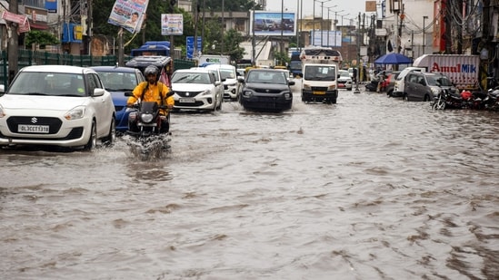 Vehicles wades through a waterlogged road after heavy rainfall, in Najafgarh, Southwest Delhi on Thursday. Vehicles wades through a waterlogged road after heavy rainfall, in Najafgarh, Southwest Delhi on Thursday.