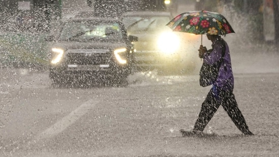 A person crosses a road amid rainfall, in New Delhi, Saturday, Aug. 9, 2025. (PTI)