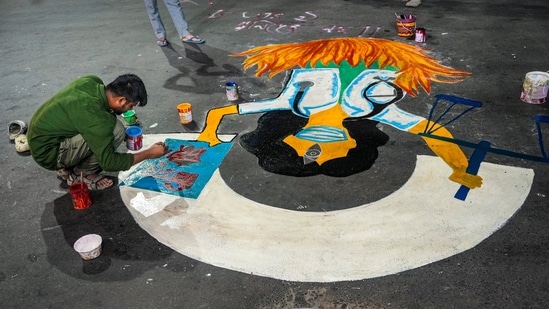 An agitator makes a graffiti during a night-long vigil organised to mark the completion of one year of the rape and murder of a trainee doctor at RG Kar hospital.(PTI)